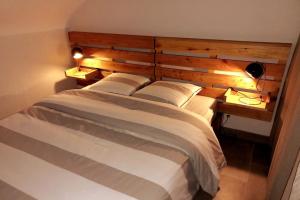 a bedroom with a large bed with a wooden headboard at Appartement-terrasse parking privé Meublé de Tourisme 4 étoiles in Belfort