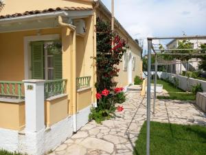 een geel huis met bloemen erop bij Kipos Apartments in Kassiopi