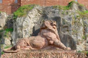 a statue of a lion sitting on a rock at Appartement-terrasse parking privé Meublé de Tourisme 4 étoiles in Belfort