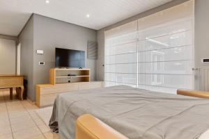 um quarto com uma cama e uma televisão de ecrã plano em Gezellige woning in Oostnieuwkerke em Staden