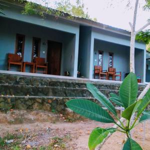 a house with chairs and a plant in front of it at Join Homestay in Kuta Lombok
