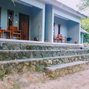 a house with a stone wall and stairs in front of it at Join Homestay in Kuta Lombok
