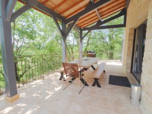 une terrasse avec une table et des chaises. dans l'établissement Magnifique Villa de prestige, piscine chauffée, à Marnac