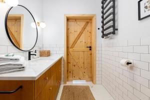 a bathroom with a sink and a wooden door at Homewell Apartments Wilson Park II in Poznań +58 photos
