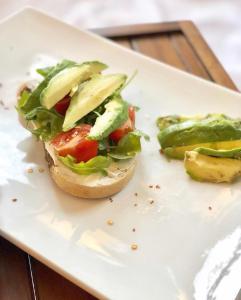 a sandwich on a plate with avocado and vegetables at Senator in Ulcinj