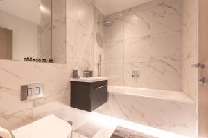 a white bathroom with a toilet and a tub at Apartment Fourteen Staines Upon Thames - Free Parking - Heathrow - Thorpe Park in Staines
