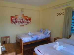 a bedroom with two beds with swans on them at Hotel Sarangkot in Pokhara