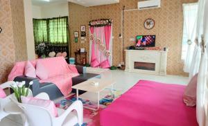 a living room with pink furniture and a fireplace at Diana Home @ Tuaran in Tuaran
