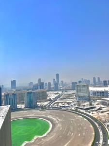 a view of a race track in front of a city at Dubai Sport City in Dubai