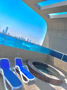 two blue chairs and a hot tub in a building at Dubai Sport City in Dubai
