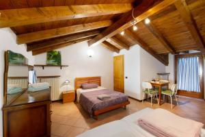 a bedroom with a bed and a desk in a room at Alla Meridiana in Bard