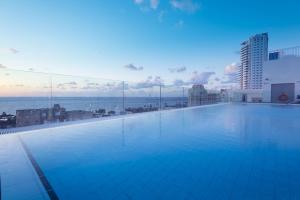 a large swimming pool with a view of the ocean at Leonardo Plaza Netanya Hotel in Netanya