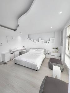 a white bedroom with a large bed and a desk at White window sea in Hengchun