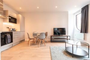 uma cozinha e sala de estar com mesa e cadeiras em Apartment Thirty Five Staines Upon Thames - Free Parking - Heathrow - Thorpe Park em Staines