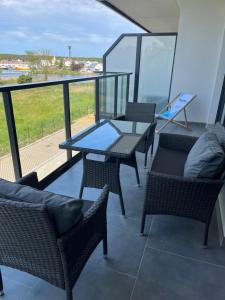 a balcony with a table and chairs and a view at Apartament Porta Mare Dziwnów in Dziwnów