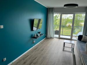 a blue living room with a couch and a table at Apartament Porta Mare Dziwnów in Dziwnów