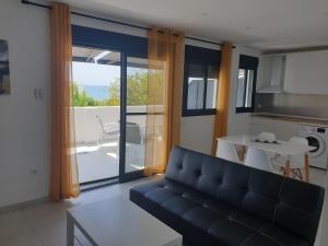 a living room with a couch and a kitchen with a balcony at APARTAMENTOS LA CALA de MIJAS in La Cala de Mijas