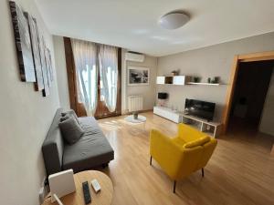 sala de estar con sofá y silla amarilla en Oupen de dor - Boggiero, en Zaragoza