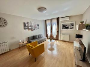 a living room with a couch and a clock on the wall at Oupen de dor - Boggiero in Zaragoza