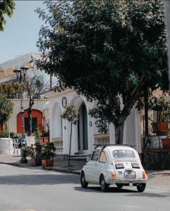 una piccola auto parcheggiata di fronte a una casa di Hotel Rosetta a Ischia