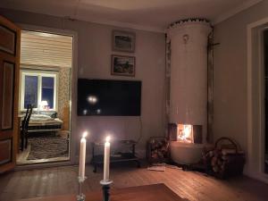 sala de estar con 2 velas y chimenea en Village Cottage In The High Coast Area 