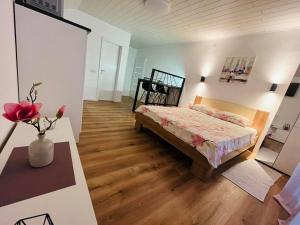 Un dormitorio con una cama y una mesa con un jarrón de flores en Apartment Bagaric, en Stari Grad