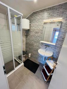 a bathroom with a sink and a shower and a mirror at Apartment Bagaric in Stari Grad