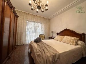 a bedroom with a large bed and a chandelier at Apartamentos Dos Torres Alfajería con parking privado gratis in Zaragoza