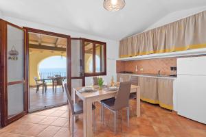 a kitchen and dining room with a table and chairs at Villa Belvedere in Costa Rei