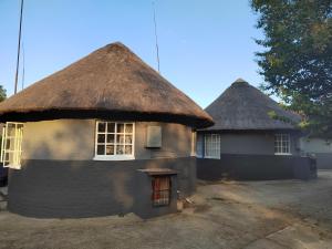 two huts with thatched roofs are shown at Graskop family retreat and backpackers in Graskop