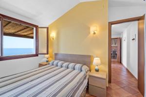 a bedroom with a bed and a large window at Villa Belvedere in Costa Rei