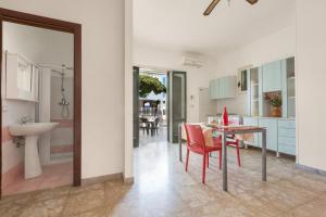 a kitchen and dining room with a table and chairs at Dima Apartments by BarbarHouse in San Foca