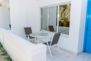 una mesa y sillas en un balcón con ventana en Fujairah Hotel & Resort en Fujairah