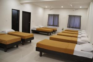 a room with four beds in a room at HOTEL ADITYA in Sasan Gir