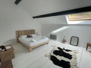 een slaapkamer met een bed en een koeienkleed bij Le Tilleul des Cloux in Auxey-Duresses