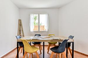 Un comedor con mesa y sillas de madera. en La Villa d'Isa et Seb, en Narbona