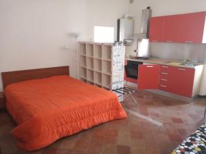 uma cama laranja num quarto com uma cozinha em ai18diamanti apartments em Saludecio