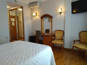 a bedroom with a bed and a desk and a mirror at Hotel Playa Compostela in Vilagarcia de Arousa