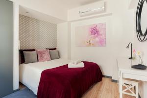 um quarto com uma cama branca e um cobertor vermelho em Blue Salinas em Aveiro