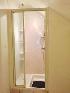 La salle de bains est pourvue d'une douche avec une porte en verre. dans l'établissement Cottage du château, à Erbrée