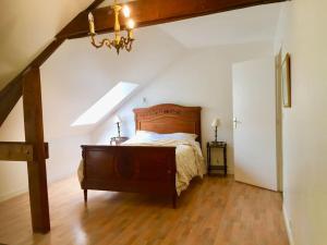 1 dormitorio con 1 cama con cabecero de madera en Cottage du château, en Erbrée