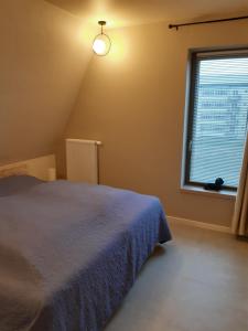 ミッデルケルケにあるAppartement inclusief garagebox te Westendeのベッドと窓のある寝室