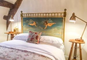 een bed met een schilderij van paarden aan de muur bij Cotswold Place in Cirencester
