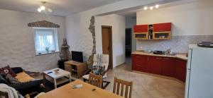 een keuken en een woonkamer met een bank en een tafel bij Ema & Marta apartment in Babići