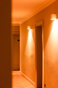 einen Flur mit zwei Lichtern an der Wand in der Unterkunft Mimosa Hotel in Westerland