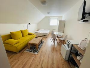 a living room with a yellow couch and a table at Penzión na Hranici Čirč in Čirč