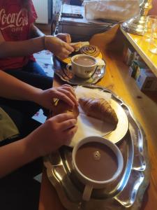 a table with a plate with a sandwich and a cup of coffee at Cuki Apartment in Budapest