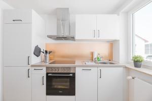 a white kitchen with white cabinets and a sink at Moderne Ferienwohnung in Lorch in Lorch