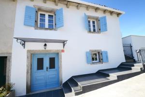 a white house with blue windows and a blue door at Holiday Home Nono Frane in Lindar
