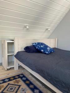 Una cama con una almohada azul encima. en Leniwa Kolonia, en Sarnaki